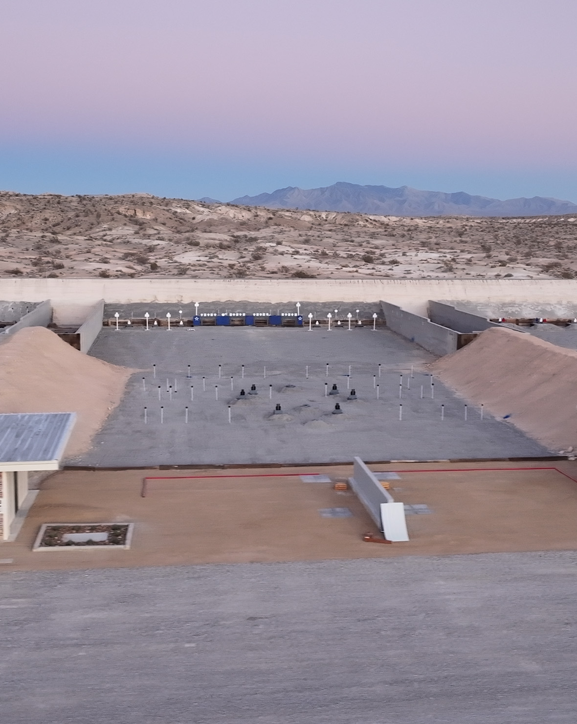 The Executive Rescue bay at dusk, cubicle frames and target arrays downrange, at Staccato Ranch Vegas.